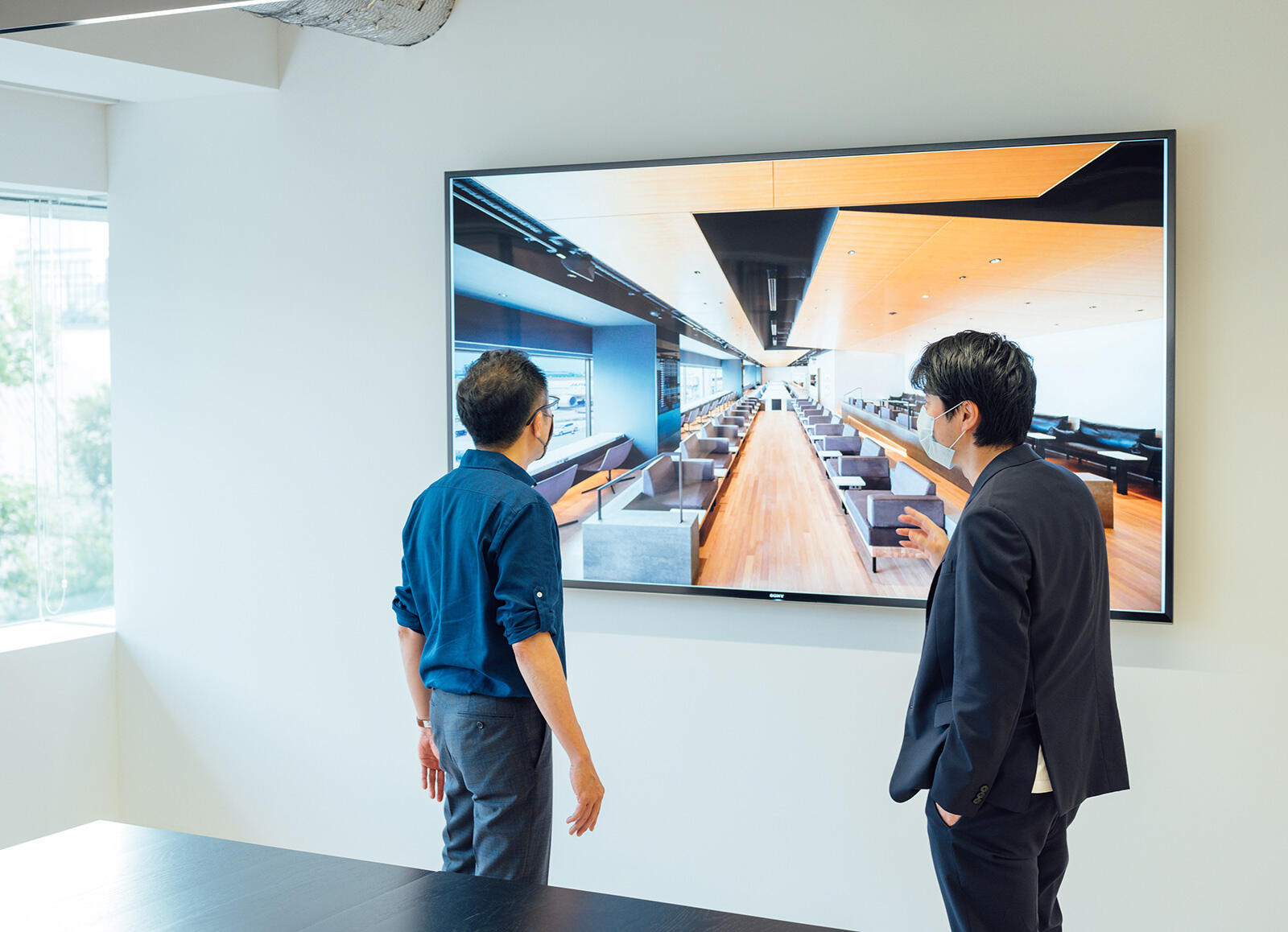 The dialog took place in the office of Takram, of which Tagawa is the Director. The image displayed on the screen is the new fee-paying lounge at Haneda Airport, 