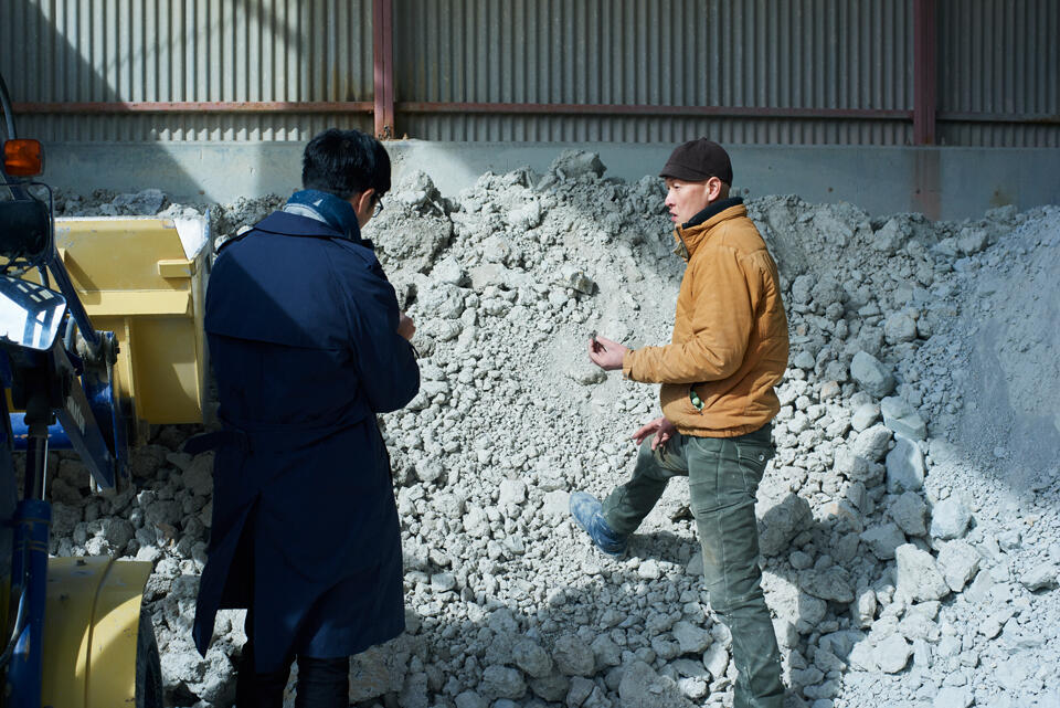 Visiting the site where Kaneri Touryo manufactures its ceramic clay guided by HIOKI Tetsuya (right), a representative of Kaneri Touryo and a ceramic artist. Clay taken from the mine is visually examined, sampled, fired and sorted. The clay is then piled up at a clay yard for aging.