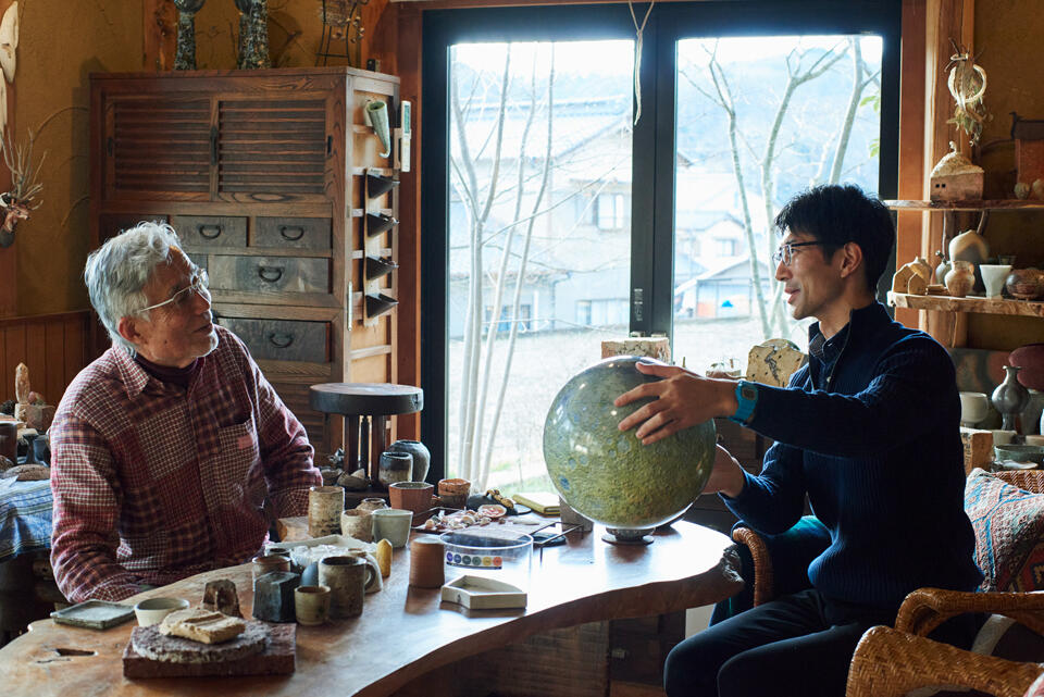 Looking at a Moon globe that Mr. Sato brought with him during a discussion at Mr. Iwashima's studio