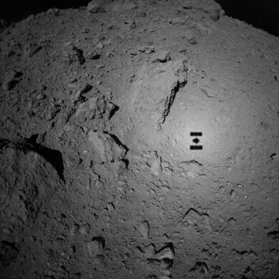 The surface of Ryugu as photographed by the Hayabusa2 asteroid explorer; Hayabusa2's shadow can also be seen in the image