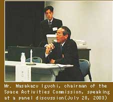 Mr. Masakazu Iguchi, chairman of the Space Activities Commission, speaking at a panel discussion (July 28, 2003) Photo