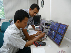 Participants in the STAR program study a small-scale satellite system.