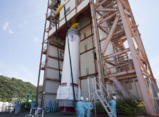 First-stage motor being lifted by crane (courtesy: JAXA/JOE NISHIZAWA)