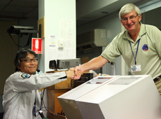 Professor Kuninaka and John McKevett, Operations Manager of the Royal Australian Air Force’s Woomera Test Range, shake hands after the capsule is discovered