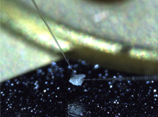 Using a probe to lift particles of Itokawa.